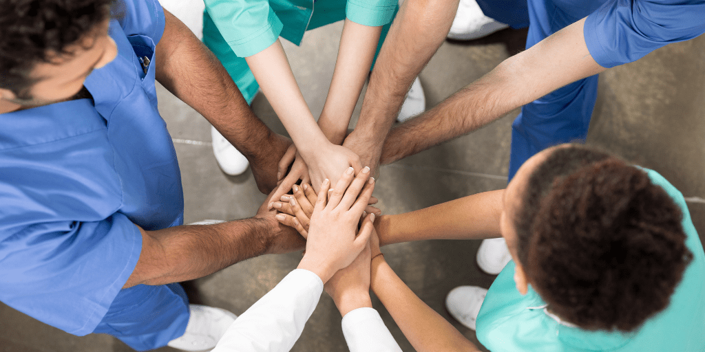 medical workers joining hands