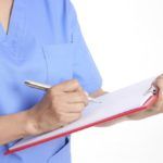 Nurse holds the chart for taking patient treatment on white background