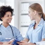 Two female nurses talking to each other
